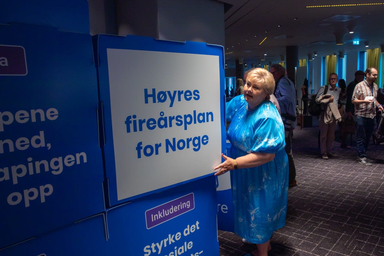 Erna Solberg ved plakat med valgløfter